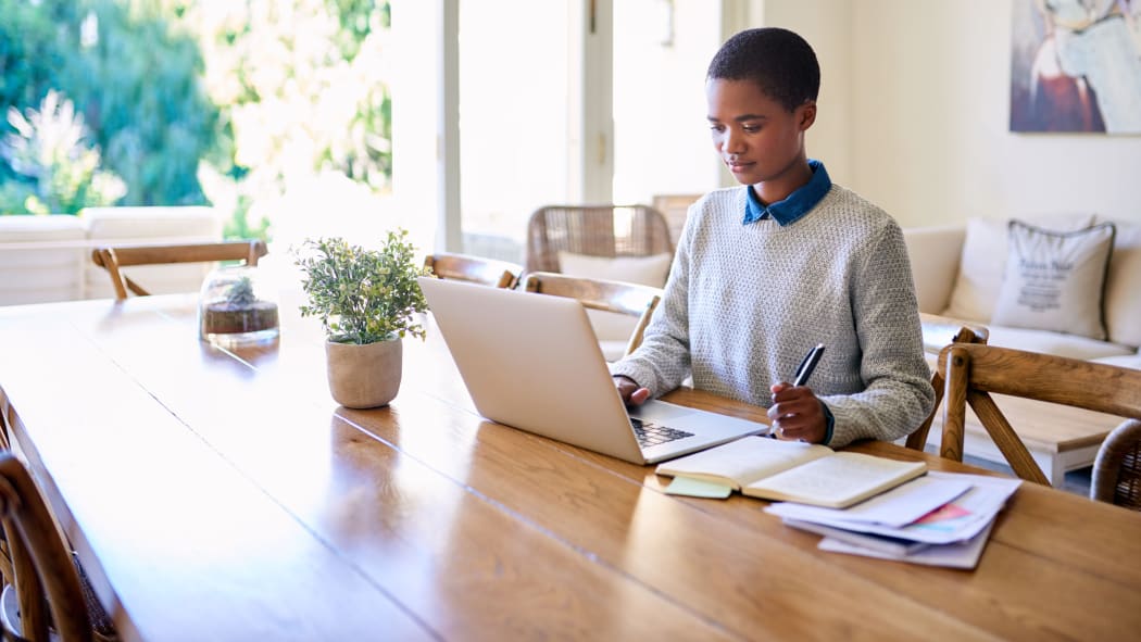woman on laptop with notebooks